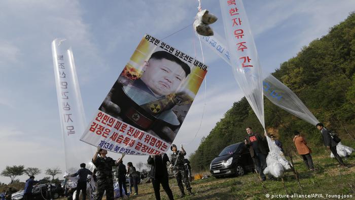 North Korean defectors prepare to release balloons carrying leaflets and a banner condemning North Korean leader Kim Jong Un