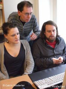 Zimmermann, Brömmel und Fabian Rosemann (von links nach rechts) sitzen vor einem Computer (Foto: DW)