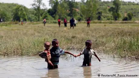 Rohingya children make their way through water 