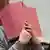Niels H hiding behind a folder in court