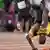 Usain Bolt überschlägt sich nach seinem Sturz im WM-Rennen. Foto: dpa-pa