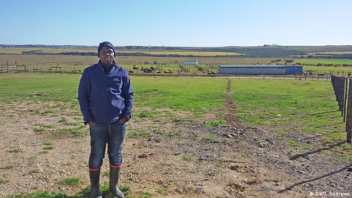 Ein schwarzer südafrikanischer Bauer steht auf seinem Land
