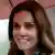 Duchess Kate smiles under an umbrella