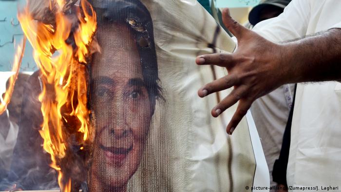 Protestors burn a picture of Suu Kyi