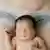 Symbolbild - Kaiserschnitt: Neugeborenes liegt auf Mutter mit Narbe durch Kaiserschnitt