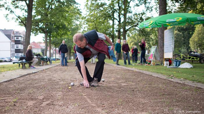 Ein Boules-Spieler bückt sich nach einer Kugel während einer Wahlkampf-Aktion von B90/Die Grünen in Osterode (Foto: DW/R. Oberhammer) 