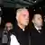 Bishop Richard Williamson, second from left in foreground, is escorted out of Heathrow airport by police and security officers