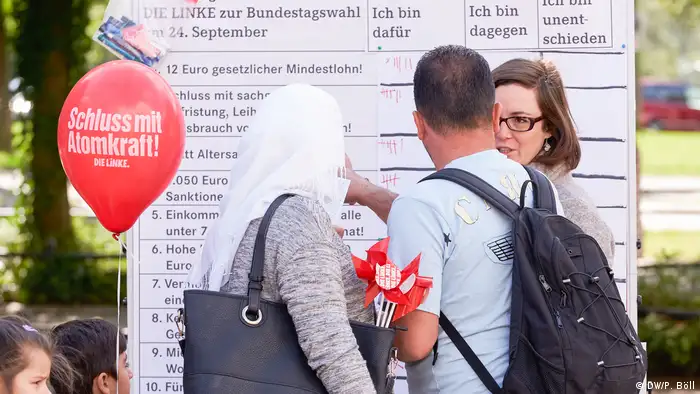 Bürger vor einem Informationsplakat der Partei Die Linke in Köln (Foto: DW/P. Böll)