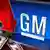 The EU's Industry Commissioner has called on the European states with General Motors factories to meet to co-ordinate their response to the US GM logo over generic stock market chart and US 100 dollar bills and DOWN arrow, on texture, partial .