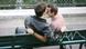 a male couple kissing on a city bench a male couple kissing on a city bench
