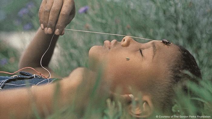 Fotografie von Gordon Parks, Boy with June Bug, Fort Scott, Kansas, 1963. Ein Junge liegt im Gras, er hat die Augen geschlossen, ein Käfer krabbelt über seine Stirn (Courtesy of The Gordon Parks Foundation)