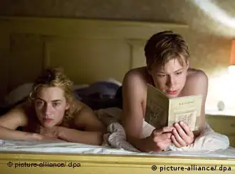 Michael Berg (David Kross) liest Hanna Schmitz (Kate Winslet) in einer Szene von Der Vorleser im Bett vor.