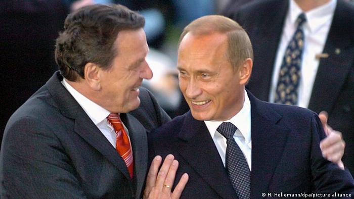 Gerhard Schröder embracing a smiling Vladimir Putin in 2004