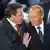 Gerhard Schröder legt Wladimir Putin die Hände auf die Schultern, beide lächeln 