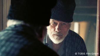 Главный герой фильма Эдуард Леандер примеряет качаью папаху