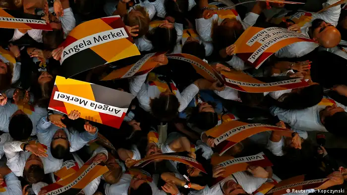 Las primeras reacciones a los resultados a boca de urna muestran a seguidores de la CDU de Angela Merkel agitando afiches con el nombre de la canciller en la capital germana.