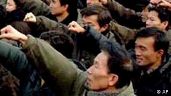 Thousands of North Koreans pump their fists in unison during a rally
