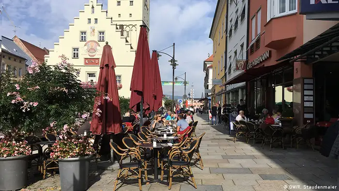 People sit outside in cafes in the Bavarian town of Deggendorf