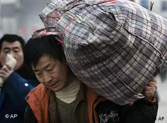 A migrant worker carries his bags as he leave the Beijing Railway Station, China, Tuesday, Dec. 16, 2008. World Bank President Robert Zoellick warned Monday that 2009 will prove to be a very difficult year for China and the world amid the financial downturn, but said the Chinese government's efforts to shore up the country's own economy will help aid global stability. (AP Photo/Andy Wong)