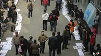 Migrant workers place their job applications on the ground to attract employers outside a labour market in Chengdu, China, Monday, Feb. 2, 2009. The global economic crisis has taken hold deep in China's impoverished countryside, as millions of rural migrants are laid off from factory jobs and left to scratch a living from tiny landholdings _ creating unsettling prospects for a government anxious to avoid social unrest. (AP Photo/Color China Photo) ** CHINA OUT **