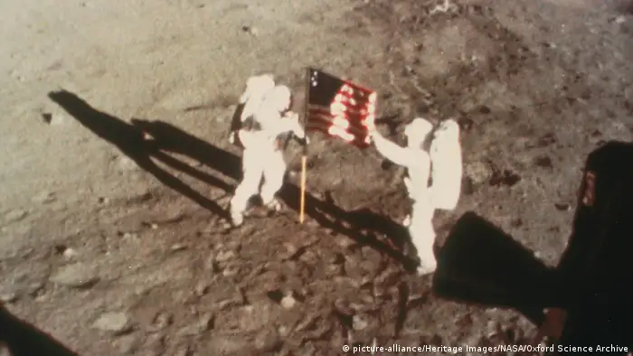 Armstrong und Aldrin mit US-Flagge auf dem Mond. 