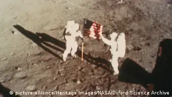 Armstrong und Aldrin mit US-Flagge auf dem Mond. 