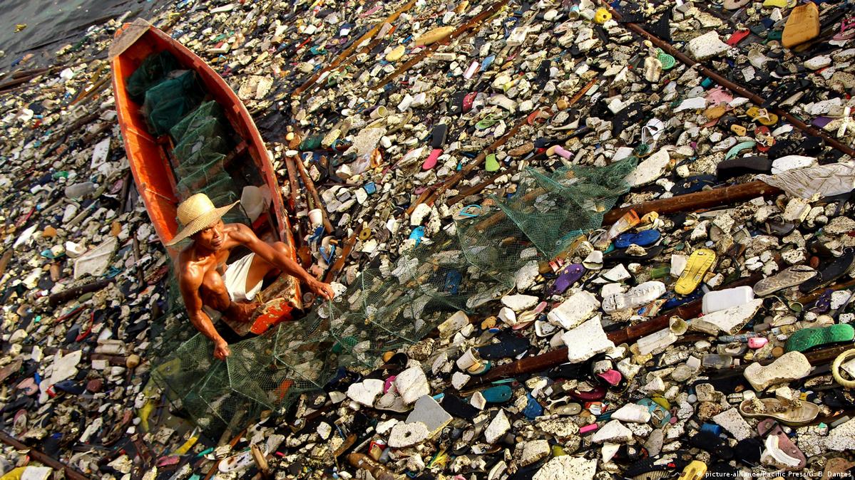 Pescador nas Filipinas retira uma armadilha para peixes e caranguejos de águas poluídas