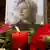 Портрет Анны Политковской, цветы и зажженная свеча