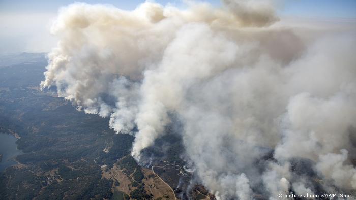 An aerial view shows wildfires spewing smoke northeast of Napa in California's wine district