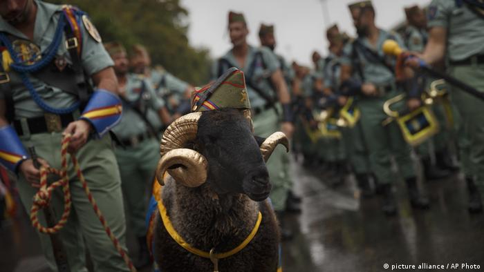 Members of La Legion, an elite unit of the Spanish Army, including a goat they use as a pet wait for the start of a military parade