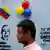 Man stands in front of a wall during Venezuela regional elections in October 2017