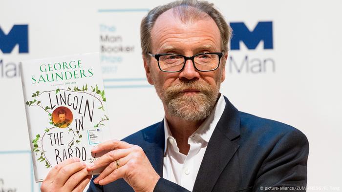 Novelist George Saunders holds up a book