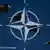 Montage Kampfjets vor dem Logo der NATO (Foto: AP/Montage: DW)