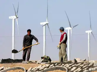 中国工人在甘肃一个风力发电站旁修建高速公路