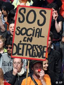 Demonstranten in Marseille, vorne ein Mann mit roter Clownnase, der ein Plakat hochhält SOS - Social en Detresse (Foto: AP)