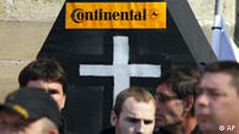 Protestierende Mitarbeiter des Reifenherstellers Continental, hinter ihnen ein Pappsarg mit einem weißen Kreuz, darüber der Conti-Schriftzug (Foto: AP)