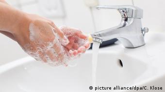 Женщина моет руки под краном