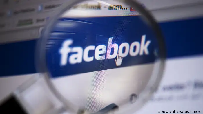 Facebook logo under a magnifying glass. 