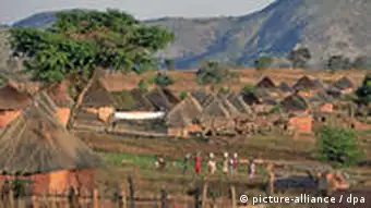 Frauen tragen Eimer mit Wasser in eine kleines Dorf in Simbabwe