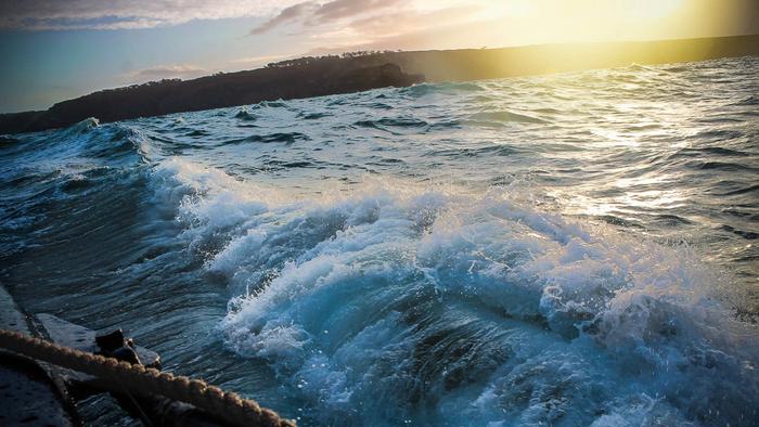 Las olas rompen contra un barco.