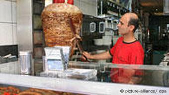 Türke schneidet im Dönerladen Fleisch vom Dönerspieß ab. (Foto: picture-alliance)