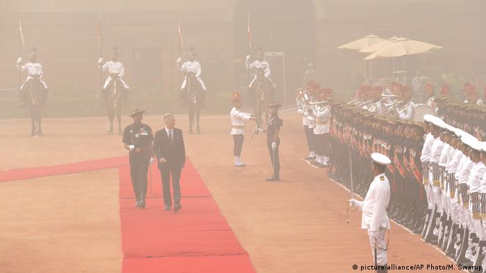 Belgium's King Philippe inspects a military guard of honor at the Indian presidential palace, surrounded by smog, in New Delhi, India