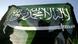 A man holds a Saudi Arabian flag A man holds a Saudi Arabian flag
