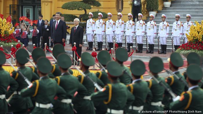 Chinese President Xi Jinping, standing with Vietnam's communist aprty General Secretary Nguyen Phu Trong, receives an honor guard welcome.