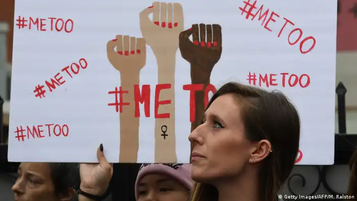 Woman at a protest march in Hollywood in front of a #MeToo banner
