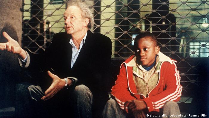 Film scene of Figures of the Night with an older man and a refugee boy, both sitting (picture-alliance/dpa/Peter Rommel Film)