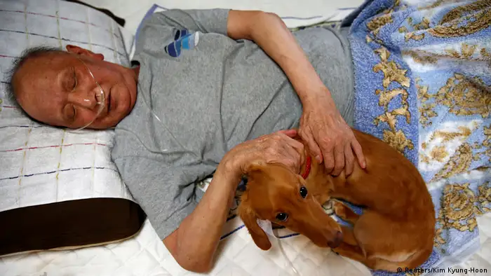 Mitsuru Niinuma lying in bed with his dog Rin (Reuters/Kim Kyung-Hoon)