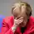 German Chancellor Angela Merkel covers her eyes