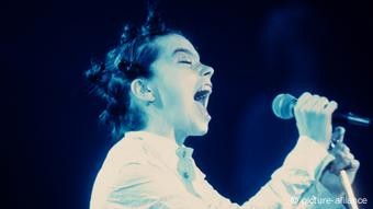 Singer Björk singing with microphone in hand.