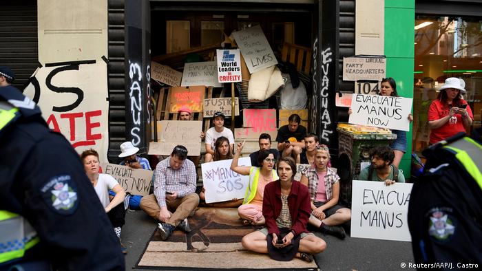 Protesters block the entrance to the Victorian Liberal party offices in Melbourne, with signs reading #Manus SOS and Evacuate Manus Now (Reuters/AAP/J. Castro)